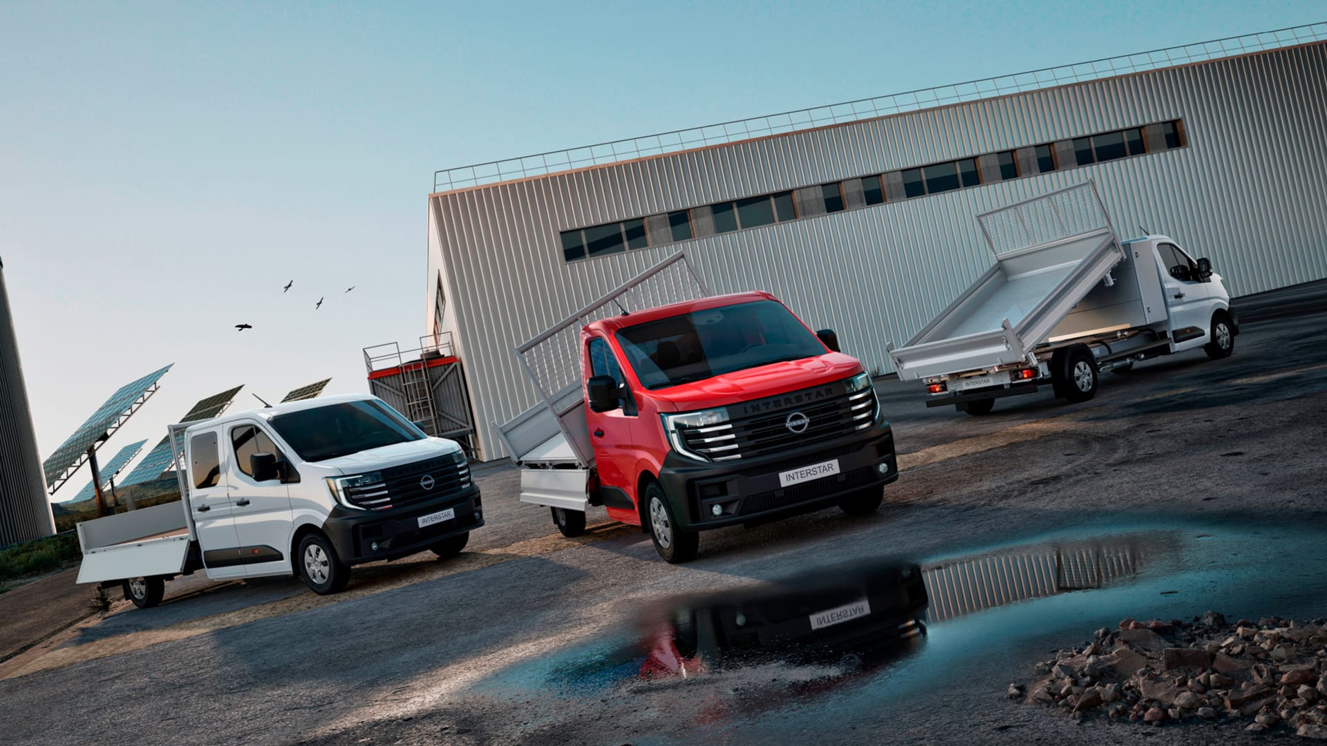 Nissan INTERSTAR fourgons et conversions garés devant des panneaux solaires